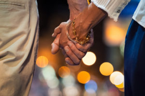 Closeup of loving married couple holding hands while walking outdoors during date night in Fairfax, VA. Counseling available to strengthen your relationship in Northern Virginia.