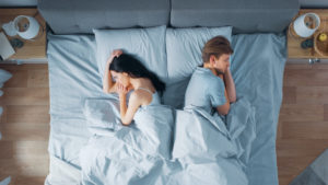 Married couple in bed, facing away from each other and looking upset about their sexless marriage. Couples therapy in Fairfax, VA can help you when the passion and intimacy is gone. Marriage counseling in Fairfax, VA can help you feel more connected at The Center for Connection, Healing and Change. 22032